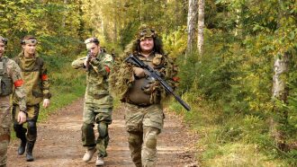 Игроки LASERWAR в полной экипировке идут по лесной тропе.