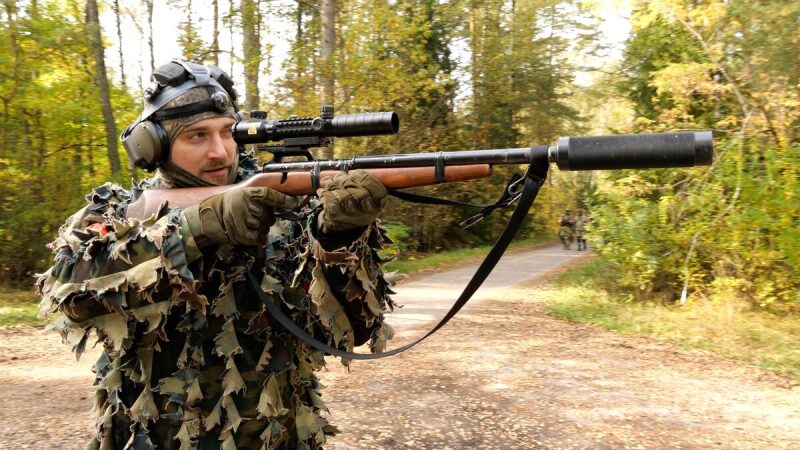 Боец LASERWAR снайперской винтовкой в осеннем лесу