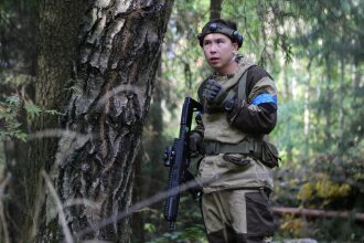 Боец LASERWAR с автоматом у ствола дерева