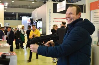 Мужчина с улыбкой демонстрирует автомат LASERWAR.