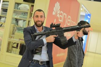 Мужчина демонстрирует автомат LASERWAR с барабанным магазином