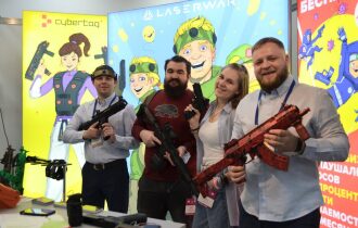 Команда LASERWAR позирует с ярким оружием.