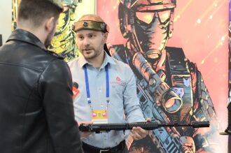 Сотрудник LASERWAR демонстрирует оружие на выставке