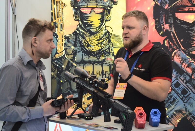Обсуждение деталей лазертаг-оружия LASERWAR на стенде.