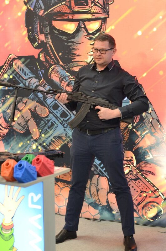 Мужчина держит автомат LASERWAR на фоне комикс-арта.