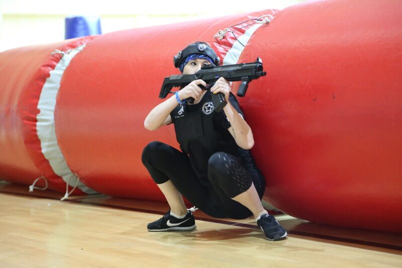 Девушка LASERWAR в низкой позиции с оружием