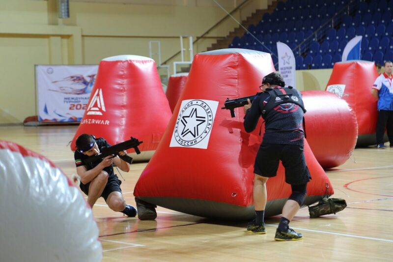 Игроки LASERWAR в низких стойках у красных укрытий.