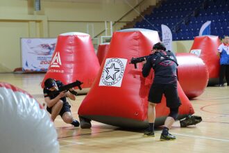 Игроки LASERWAR в низких стойках у красных укрытий.