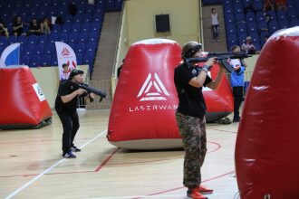 Игроки LASERWAR занимают позиции у надувных препятствий.
