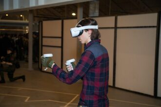 Молодой человек в VR-очках управляет виртуальной реальностью.