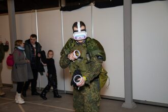 Игрок в VR-гарнитуре LASERWAR с контроллерами в руках.