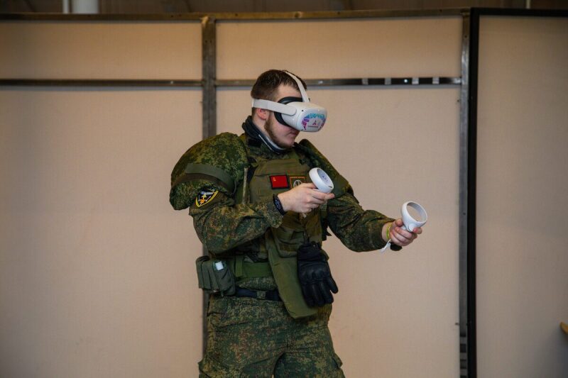Игрок в VR-гарнитуре LASERWAR с контроллерами активно управляет игрой.