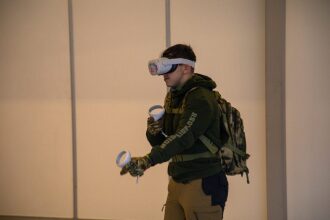 Молодой человек в VR-гарнитуре LASERWAR управляет виртуальным миром.