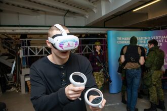 Молодой человек в VR-гарнитуре LASERWAR управляет игрой.