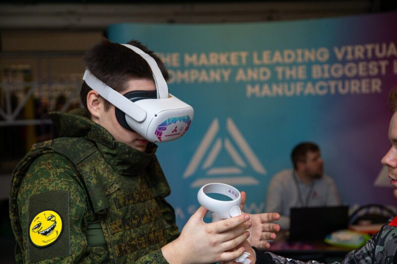 Молодой человек в камуфляже пробует VR-гарнитуру LASERWAR.