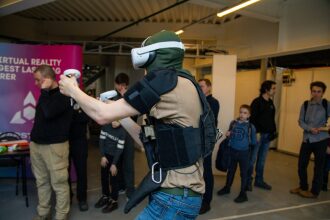 Игрок в VR-шлеме LASERWAR с контроллерами активно управляет игрой.