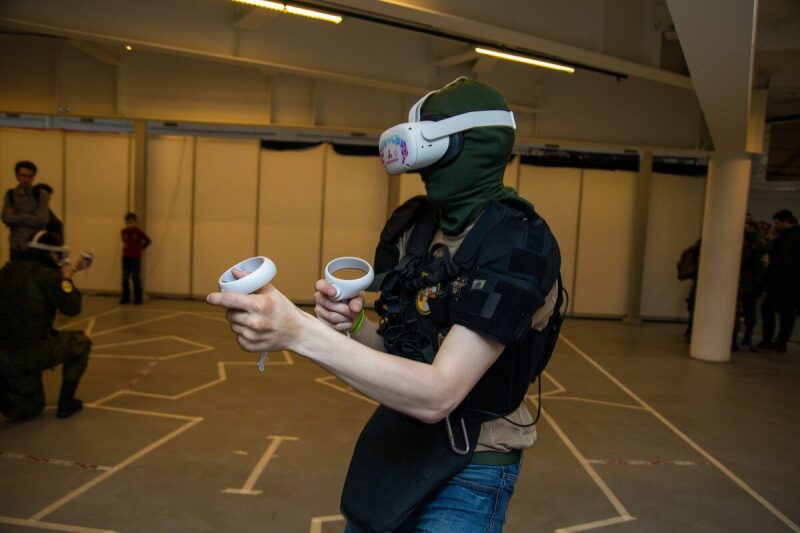 Игрок в VR-гарнитуре LASERWAR с контроллерами осваивает виртуальный мир
