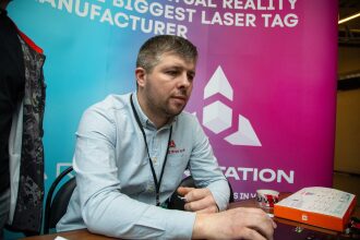 Мужчина в рубашке LASERWAR работает за ноутбуком.