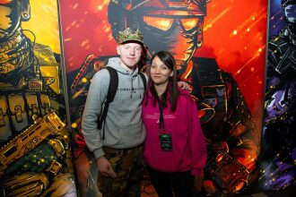 Пара на фоне ярких стендов LASERWAR.