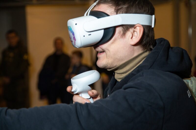 Молодой человек в VR-гарнитуре LASERWAR осваивает виртуальную реальность