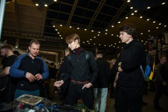 Мужчины изучают лазертаг-оборудование на выставке LASERWAR.