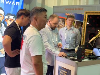 Мужчины у стенда LASERWAR изучают ноутбук.