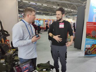 Два мужчины обсуждают оборудование LASERWAR на выставке.