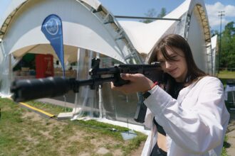 Девушка целится из автомата LASERWAR.