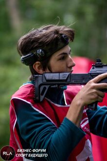 Игрок LASERWAR в красном жилете с винтовкой нацелился.