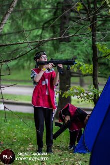 Юный стрелок LASERWAR в красном жилете прицеливается.
