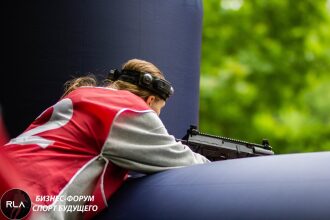 Девушка в красном жилете LASERWAR ведет прицельный огонь.
