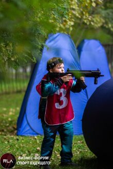 Мальчик в красном жилете с винтовкой LASERWAR целится.