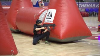 Мальчик в черной форме LASERWAR прицеливается