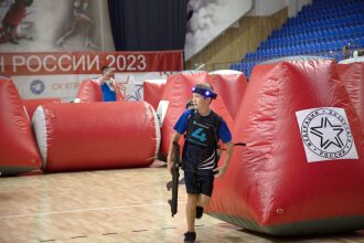 Юный игрок LASERWAR с оружием бежит между препятствиями