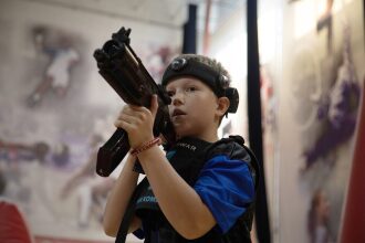 Мальчик в шлеме LASERWAR с оружием готов к бою