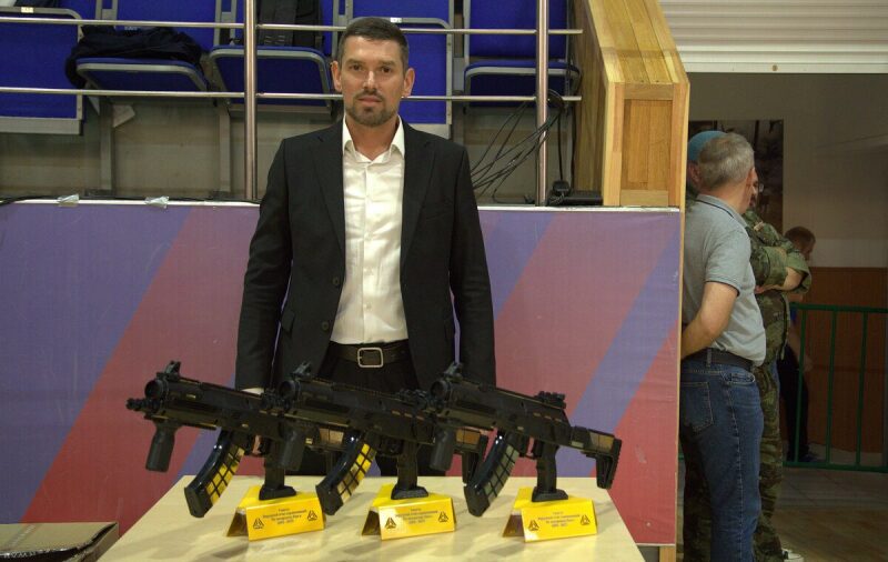 Мужчина в костюме демонстрирует лазертаг-оружие LASERWAR
