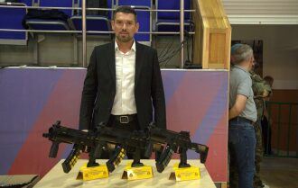 Мужчина в костюме демонстрирует лазертаг-оружие LASERWAR