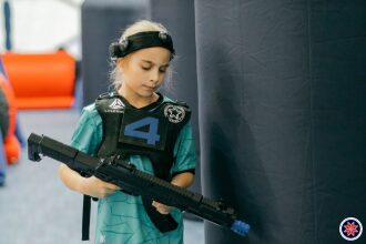 Юный лазертаг-боец готовится к игре с автоматом LASERWAR.