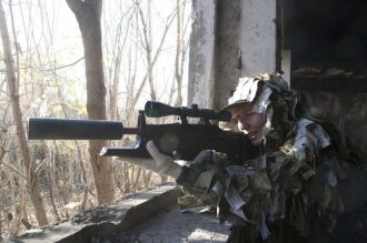 Снайпер LASERWAR в камуфляже готов к выстрелу.