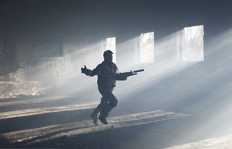 Боец LASERWAR врывается в помещение, освещенное лучами света.