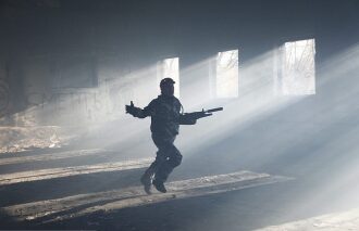 Боец LASERWAR врывается в помещение, освещенное лучами света.