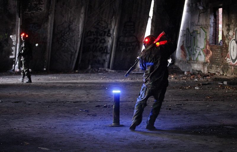 Лазертаг-бойцы в заброшенном здании с синим маячком
