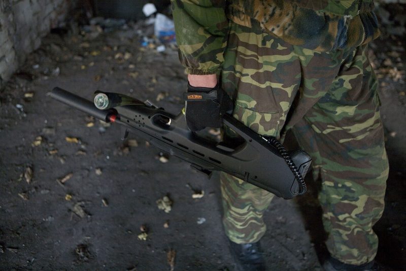 Боец LASERWAR с футуристичным оружием в заброшенном здании.