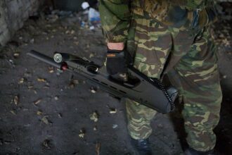 Боец LASERWAR с футуристичным оружием в заброшенном здании.