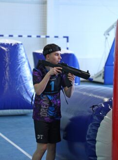 Игрок в синей команде с лазертаг-винтовкой наготове.