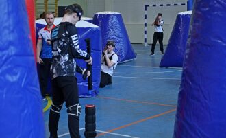 Игроки LASERWAR в синих надувных укрытиях ведут бой.