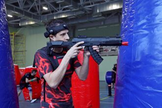 Игрок LASERWAR в черной футболке с молниями целится