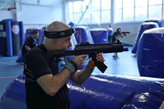 Игрок LASERWAR с автоматом занял позицию за надувным укрытием.