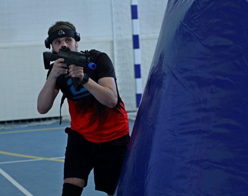 Игрок LASERWAR за синим укрытием готовится к атаке.