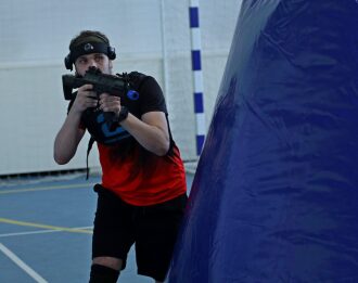 Игрок LASERWAR за синим укрытием готовится к атаке.